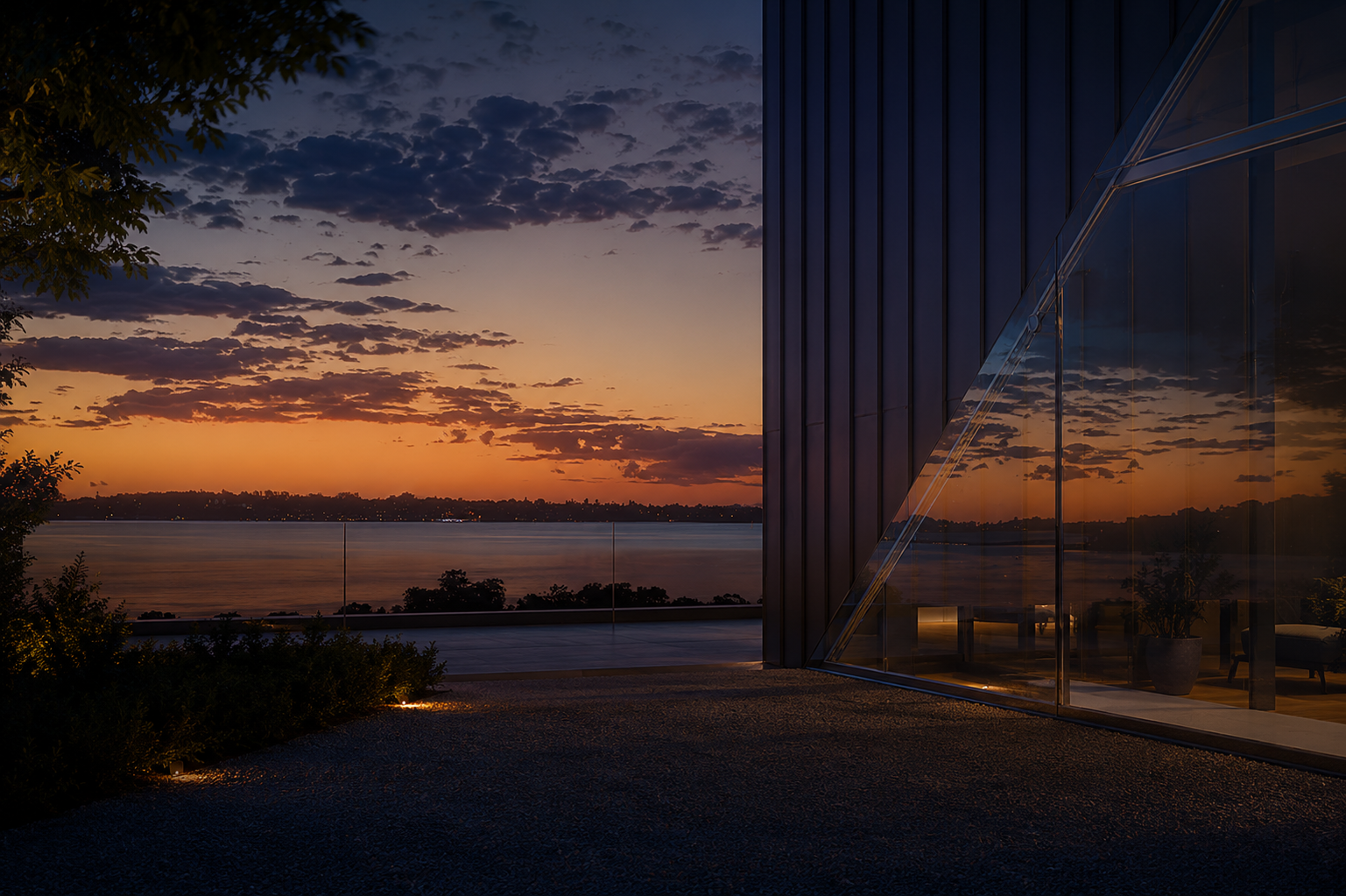 Contemporary residential architecture overlooking water at sunset